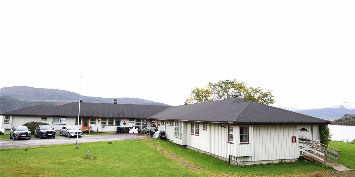 hvit bygning med grønt gress og utsikt mot havet - Klikk for stort bilde