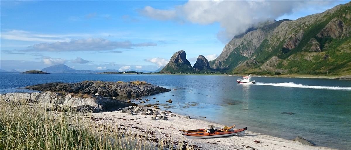 Kanoer som ligger i strandkanten med Tomma i Bakgrunnen - Klikk for stort bilde