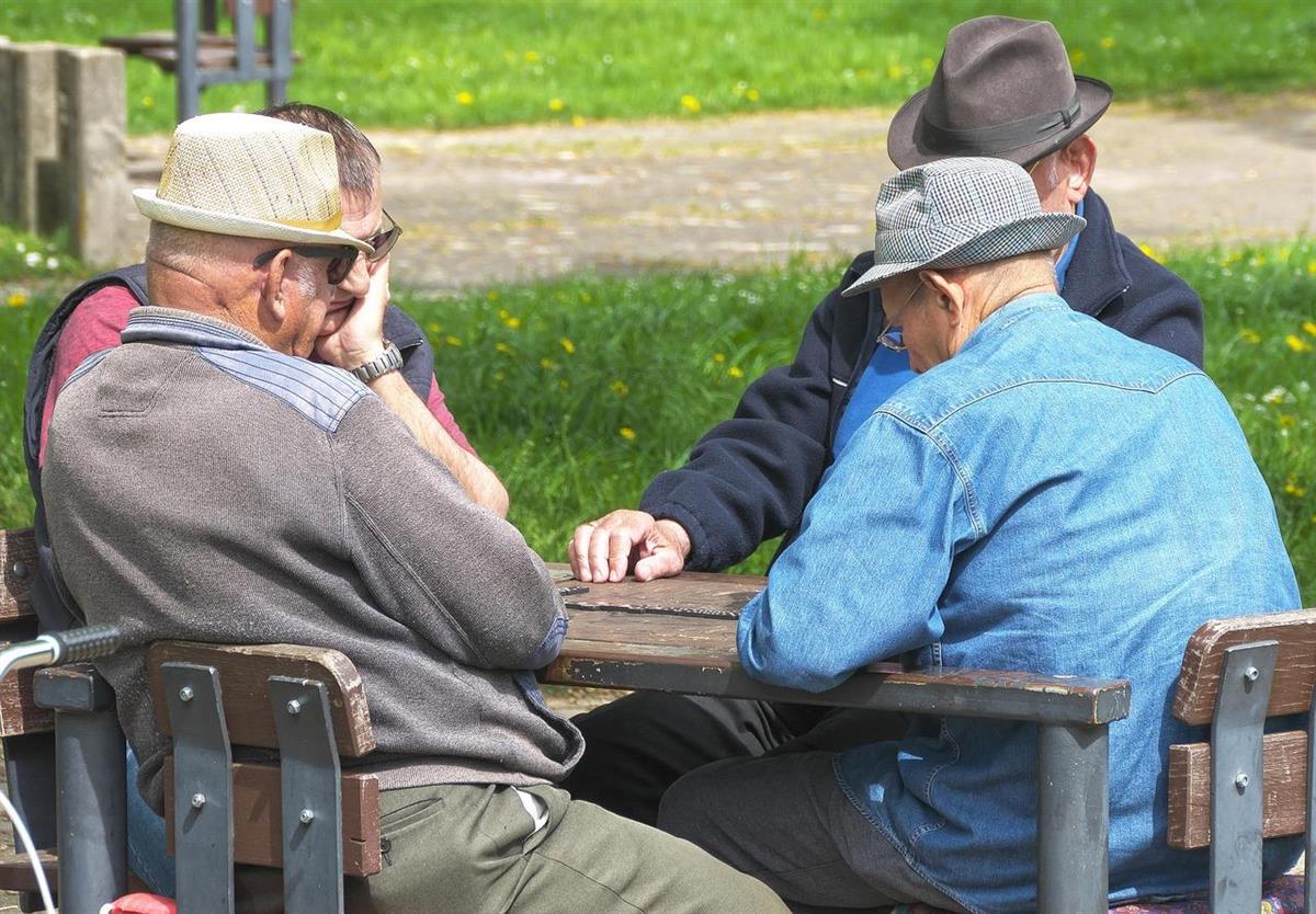 4 eldre menn som sitter rundt et bord - Klikk for stort bilde